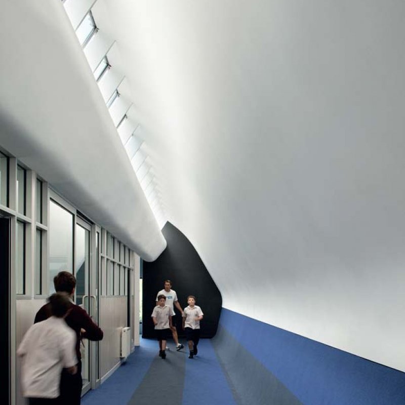 The steel ‘sausage’ extrusion of the Nicholson Street profile creates an unusual roof line and engaging spaces inside, particularly on the upper-level where classrooms with curved ceilings are painted in a vivid blue colour scheme to create a “floating in the clouds” experience for Year 6 students. 